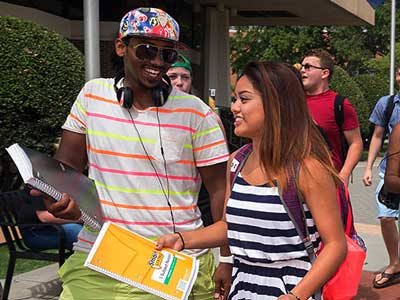 happy v.c.u. students walking together on campus on a sunny day