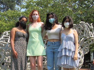 four students standing in front of a modern sculpture outside harris hall at v.c.u.